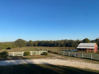 The farm with its red barn and white fence